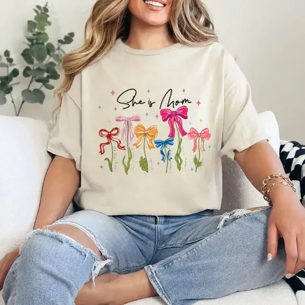 20-1-6.webp She Is Mom T-Shirt – Retro Coquette Bow Christian Mom Shirt, Bible Verse 'She Is Strong' Tee, Cute Mother's Day Gift for Faithful Mama