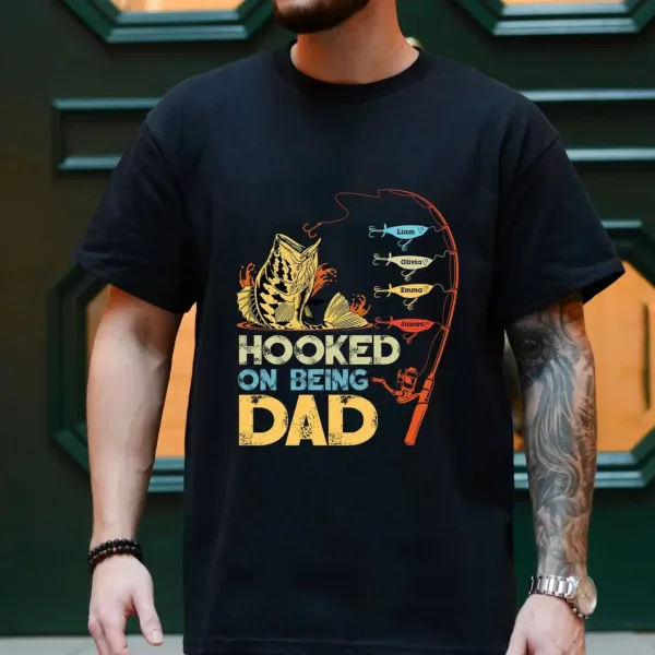 Personalized-Hooked-On-Being-Dad-Fishing-Shirts-2.webp Personalized Hooked On Being Dad Fishing Shirts, Vintage Dad Shirt, Best Dad T-Shirt, Funny Fishing Shirts For Men, Gifts For Fisherman